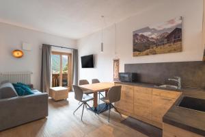 a kitchen and living room with a table and a couch at Kriendl Nr 3 in Valdaora
