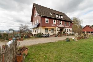 a large building with a cafe outside of it at Pension Waldliesel in Dornstetten