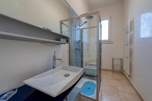 ein Badezimmer mit weißem Waschbecken und Dusche in der Unterkunft Dimora Storica Minioti intera in Arnesano + 25 Fotos