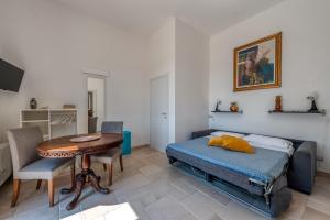 ein Schlafzimmer mit einem Bett, einem Tisch und einem Schreibtisch in der Unterkunft Dimora Storica Minioti intera in Arnesano