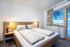 a bedroom with a large bed and a window at Haus Sabrina Hexenkopf in See