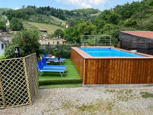 a swimming pool with a wooden fence and blue chairs at Casa Vacanze Chianti Summer in Gaiole in Chianti