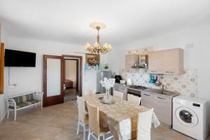 a kitchen with a table and a refrigerator and a sink at Holidayshouse in Ercolano +15 photos