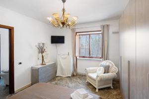 a living room with a chair and a chandelier at Holidayshouse in Ercolano