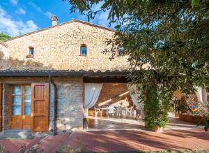 an external view of a stone house with a patio at La Ripa - Appartamento Padronale in San Gimignano