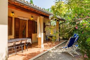 a house with chairs and a table in the yard at Fresia Quadrilocale in Marina di Grosseto