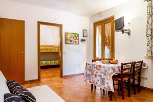 a dining room with a table with chairs and a television at Fresia Quadrilocale in Marina di Grosseto