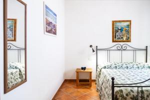 a bedroom with a bed and a mirror at Fresia Quadrilocale in Marina di Grosseto +21 photos