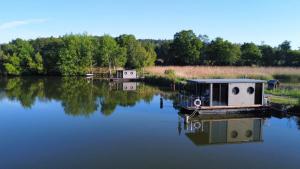 a small boat is docked on a lake at Hausboot Schwanennest in Kirchberg an der Raab +10 photos