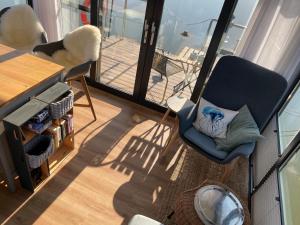 a living room with a chair and a balcony at Hausboot Schwanennest in Kirchberg an der Raab