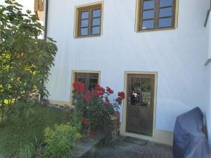 a white house with a door and some flowers at Haus Sonnenblume in Weilheim