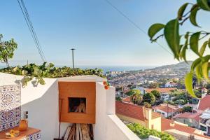 a balcony with a fireplace and a view of a city at A Minha Casa in Funchal
