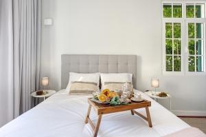 a bedroom with a white bed with a tray of fruit on a table at A Minha Casa in Funchal