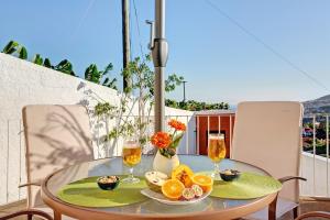 a table with glasses of wine and oranges on a balcony at A Minha Casa in Funchal