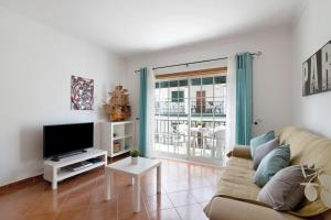 a living room with a couch and a tv at Algarvio ao Sol in Conceição
