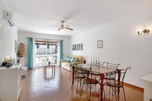 a dining room and living room with a table and chairs at Algarvio ao Sol in Conceição