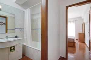a bathroom with a tub and a sink and a shower at Algarvio ao Sol in Conceição +13 photos