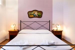 a bedroom with a white bed with two night stands at Capracotta - Aurora in Montemassi +26 photos
