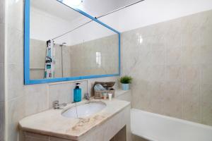 a bathroom with a sink and a mirror and a tub at Apartamento Vila Mourisca in Porches +19 photos