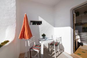 an orange umbrella sitting next to a white table and chairs at Apartamento Vila Mourisca in Porches