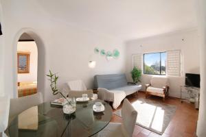 a living room with a glass table and chairs at Apartamento Vila Mourisca in Porches