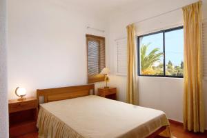 a bedroom with a bed and a large window at Apartamento Vila Mourisca in Porches