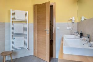 a bathroom with two sinks and a wooden door at Rotkäppchen Schlosshof in Völs am Schlern +33 photos