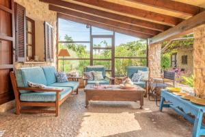 a patio with couches and tables and windows at Villa Can Sol in Pollença