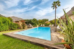 a swimming pool in a yard with a wooden deck at Villa Can Sol in Pollença