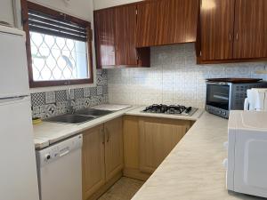 a kitchen with wooden cabinets and a sink and a stove at Villa Sylvie- Cerca Playa Riells- 4 in L'Escala +16 photos