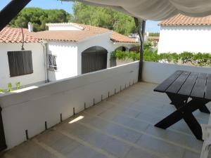 a balcony with a wooden table and a white wall at Villa Sylvie- Cerca Playa Riells- 4 in L'Escala