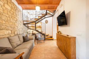 a living room with a couch and a staircase at Cal Comorera in Masoteras