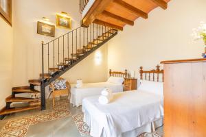 a living room with two beds and a staircase at Cal Comorera in Masoteras +33 photos