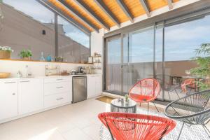 a kitchen with red chairs and a large window at Cal Comorera in Masoteras