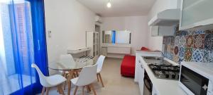 a kitchen with a glass table and white chairs at C 210 Puntavilla in La Maddalena