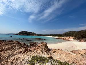 a beach with rocks and the ocean on a cloudy day at C 210 Puntavilla in La Maddalena