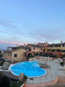 a large swimming pool in a courtyard with buildings at C 210 Puntavilla in La Maddalena