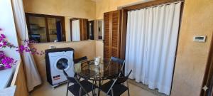 a small dining room with a glass table and a washing machine at C 210 Puntavilla in La Maddalena +2 photos