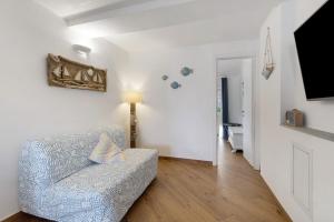 a living room with a couch and a television at Bedliving Nel Blu in Genoa