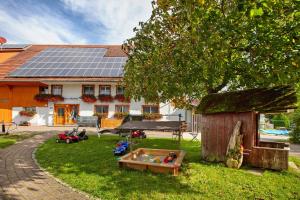 a house with solar panels on top of a yard at Haus Trötschler in Weilheim