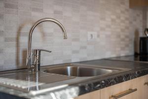 a kitchen sink with water coming out of it at Apartment Pustertal in Mühlbach +16 photos
