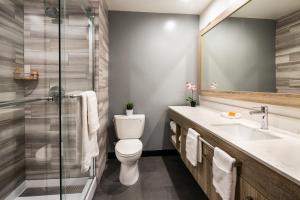 a bathroom with a toilet and a sink and a shower at Canoga Hotel at Warner Center in Canoga Park
