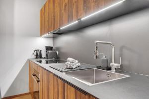 a kitchen with a stainless steel sink and wooden cabinets at Alpin Chalet Samer in Sarntal +37 photos
