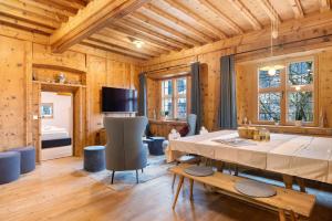 a dining room with a table and a bedroom at Alpin Chalet Samer in Sarntal