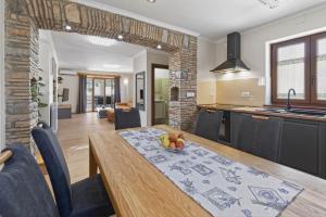 a kitchen and dining room with a wooden table and chairs at Holiday Home Pahari by Rent Istria in Roč