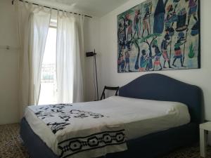 a bedroom with a bed with a painting on the wall at Vista Castello - Otranto in Otranto