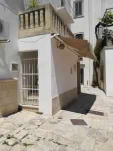 a white building with a gate and a balcony at Vista Castello - Otranto in Otranto