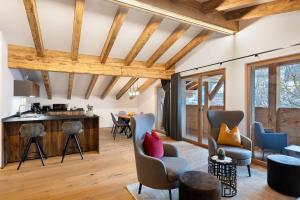 a living room with wooden ceilings and chairs and a table at Alpin Chalet Samer in Sarntal