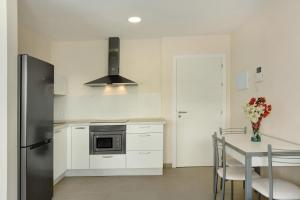 a kitchen with a refrigerator and a table with chairs at Albamar 1d in Puerto de Mogán +10 photos