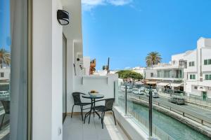 a balcony with a table and chairs and a view of the water at Albamar 1d in Puerto de Mogán